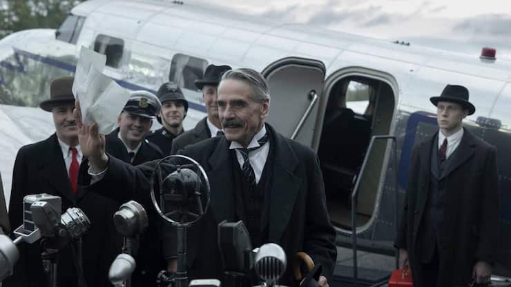 Munich - The Edge of War. (L to R) Jeremy Irons as Neville Chamberlain, George MacKay as Hugh Legat, in Munich - The Edge of War.
