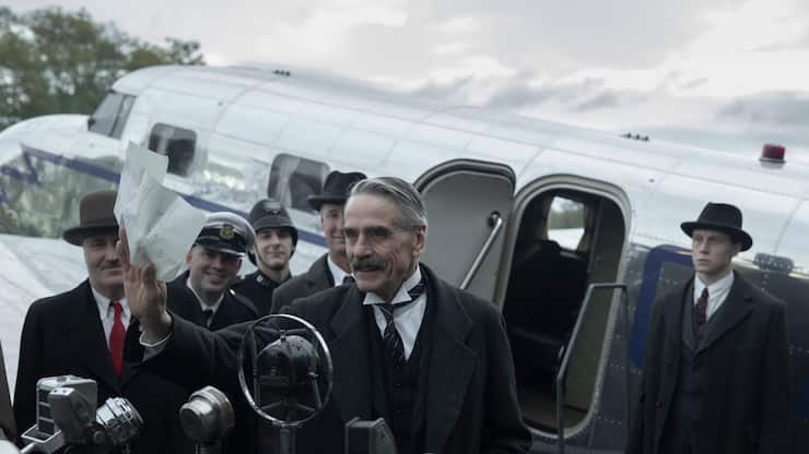 Munich - The Edge of War. (L to R) Jeremy Irons as Neville Chamberlain, George MacKay as Hugh Legat, in Munich - The Edge of War. Cr. Courtesy of Netflix Â© 2021