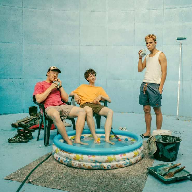 BlaBla (Sebastian Jakob Doppelbauer, l.), Carlo (Jeremias Meyer, M.) und Aydin (David Ali Rashed, r.) haben eine Güllegrube blau gestrichen und wollen daraus ihren eigenen Pool mit Beach basteln.