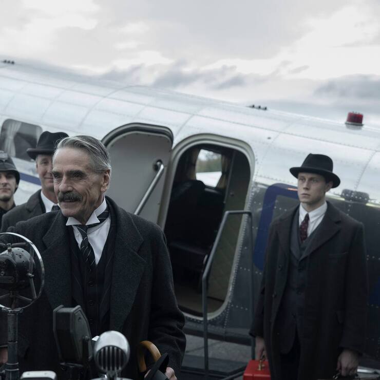 Munich - The Edge of War. (L to R) Jeremy Irons as Neville Chamberlain, George MacKay as Hugh Legat, in Munich - The Edge of War.
