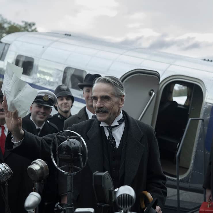 Munich - The Edge of War. (L to R) Jeremy Irons as Neville Chamberlain, George MacKay as Hugh Legat, in Munich - The Edge of War. Cr. Courtesy of Netflix Â© 2021